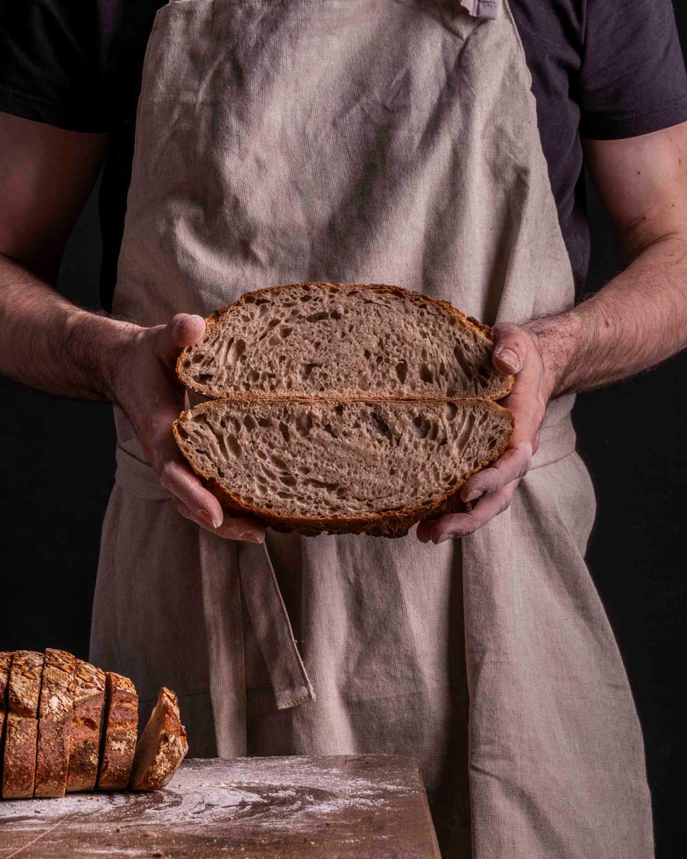Cru bakker met vers brood in handen